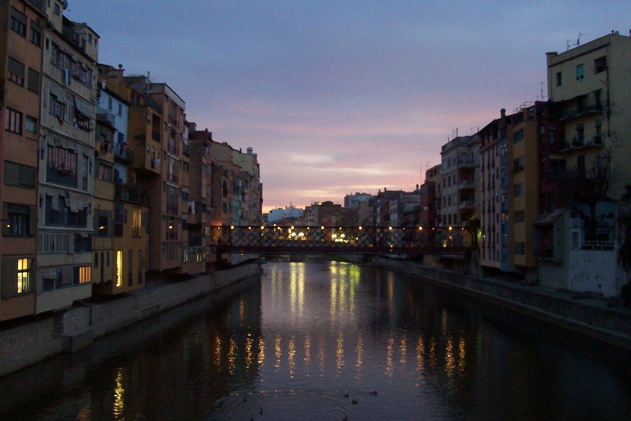Girona’s Onyar houses and Eiffel bridge reflected in the river at blue hour