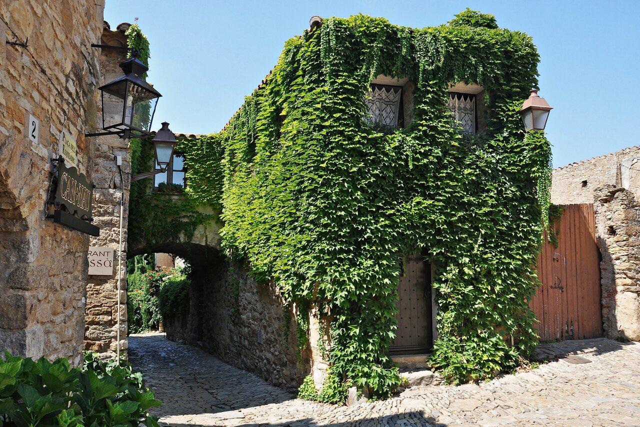 Ivy-covered stone house on a narrow lane in nearby Peratallada